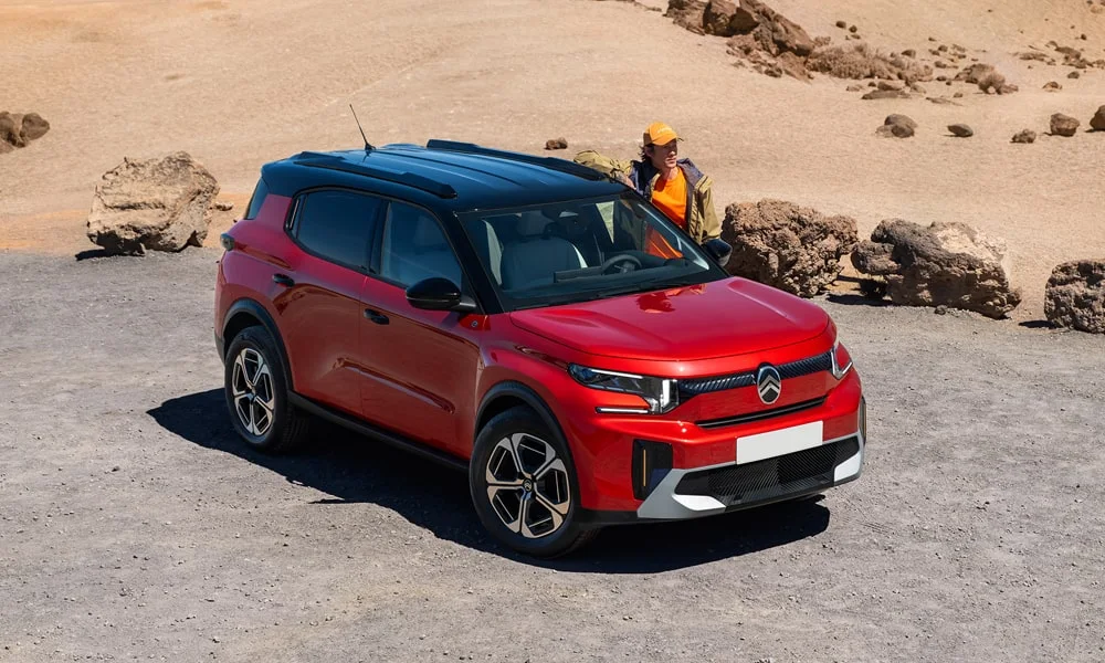 Фото Citroen C3 Aircross (2024) — вид спереди, фото 8. Передок в красном исполнении — крупная светотехника и выразительный бампер. Рисунок ходовых огней — подпись модели, по нему её узнают в потоке Citroen C3 Aircross (2024) — вид спереди, фото 8