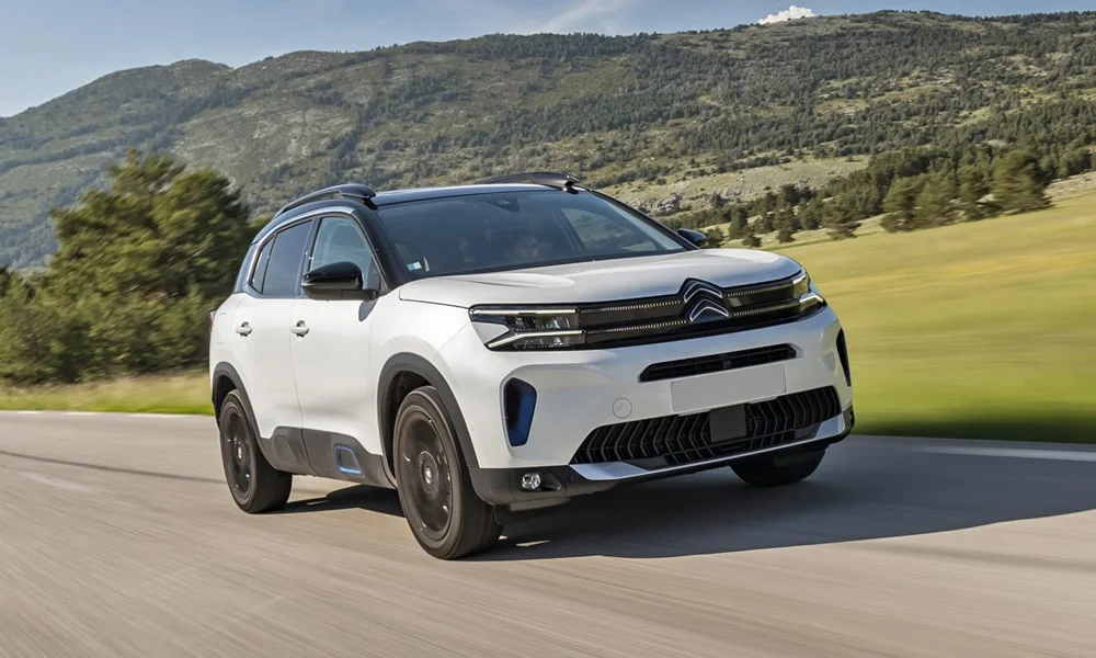 Фото Citroen C5 Aircross (2024) — вид спереди, фото 8. Кузов в белом цвете: рисунок оптики и решётки задаёт узнаваемое «лицо» модели. Рисунок ходовых огней — подпись модели, по нему её узнают в потоке Citroen C5 Aircross (2024) — вид спереди, фото 8