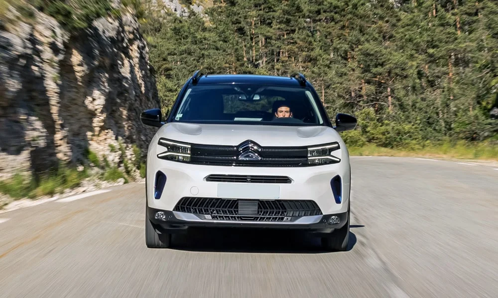 Фото Citroen C5 Aircross (2024) — вид спереди, фото 9. Передок в белом исполнении — крупная светотехника и выразительный бампер. Дневные ходовые огни включаются автоматически с запуском Citroen C5 Aircross (2024) — вид спереди, фото 9