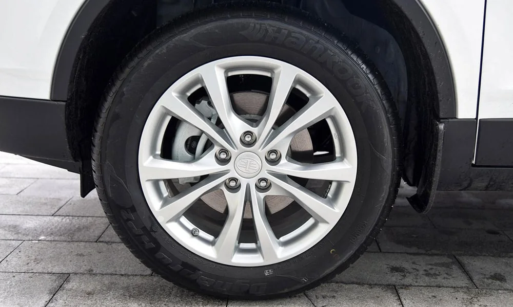 Фото FAW Besturn X80 — колесо и диск. Дизайн спиц и профиль резины крупным планом. Рекомендованные размеры шин и давление — на табличке в проёме водительской двери FAW Besturn X80 — колесо и диск