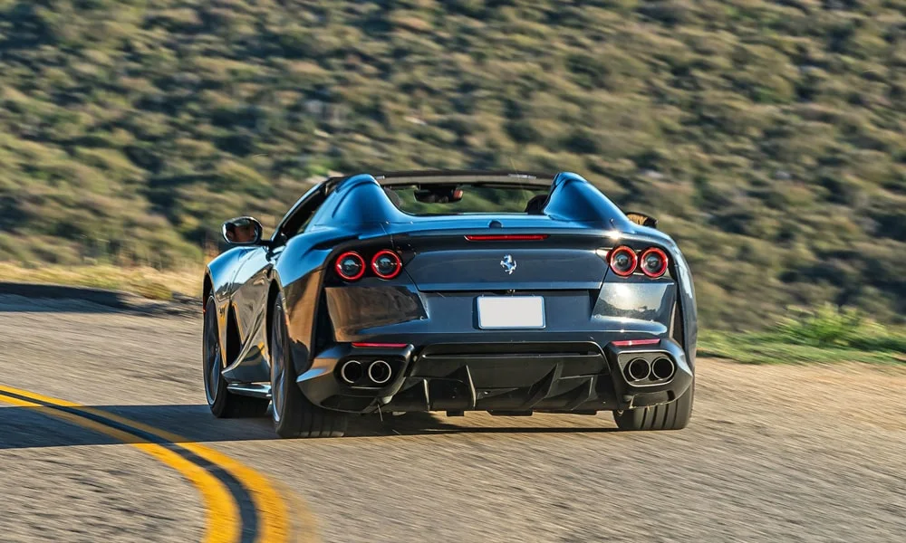 Фото Ferrari 812 GTS — вид сзади, фото 3. Линия крыши, стойки и задняя дверь в чёрном исполнении. Насадки выхлопа или их имитация внизу бампера различают версии Ferrari 812 GTS — вид сзади, фото 3
