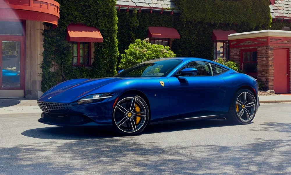 Фото Ferrari Roma — вид спереди, фото 7. Кузов в синем цвете: рисунок оптики и решётки задаёт узнаваемое «лицо» модели. Рисунок ходовых огней — подпись модели, по нему её узнают в потоке Ferrari Roma — вид спереди, фото 7