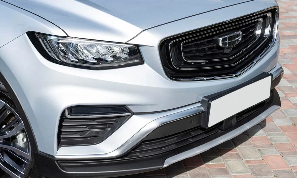 Фото Geely Atlas Pro — вид спереди, фото 7. Кузов в серебристом цвете: рисунок оптики и решётки задаёт узнаваемое «лицо» модели. Рисунок ходовых огней — подпись модели, по нему её узнают в потоке Geely Atlas Pro — вид спереди, фото 7