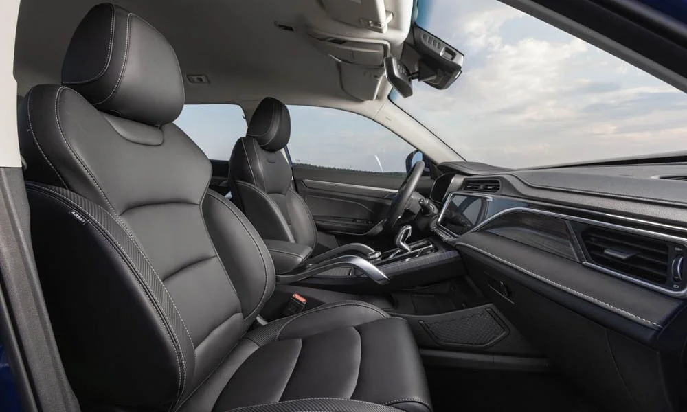 Фото Geely Atlas Pro — передние сиденья. Передние кресла в перфорированной коже. Выраженная боковая поддержка держит в поворотах Geely Atlas Pro — передние сиденья