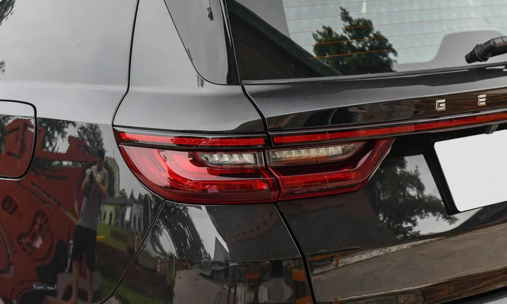 Фото Geely Emgrand X7 (2024) — задние фонари. Графика секций крупным планом — ночная подпись модели. Динамические поворотники с бегущей индикацией встречаются в старших комплектациях Geely Emgrand X7 (2024) — задние фонари