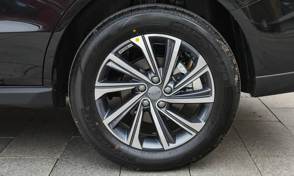 Фото Geely Emgrand X7 (2024) — колесо и диск. Дизайн спиц и профиль резины крупным планом. Рекомендованные размеры шин и давление — на табличке в проёме водительской двери Geely Emgrand X7 (2024) — колесо и диск