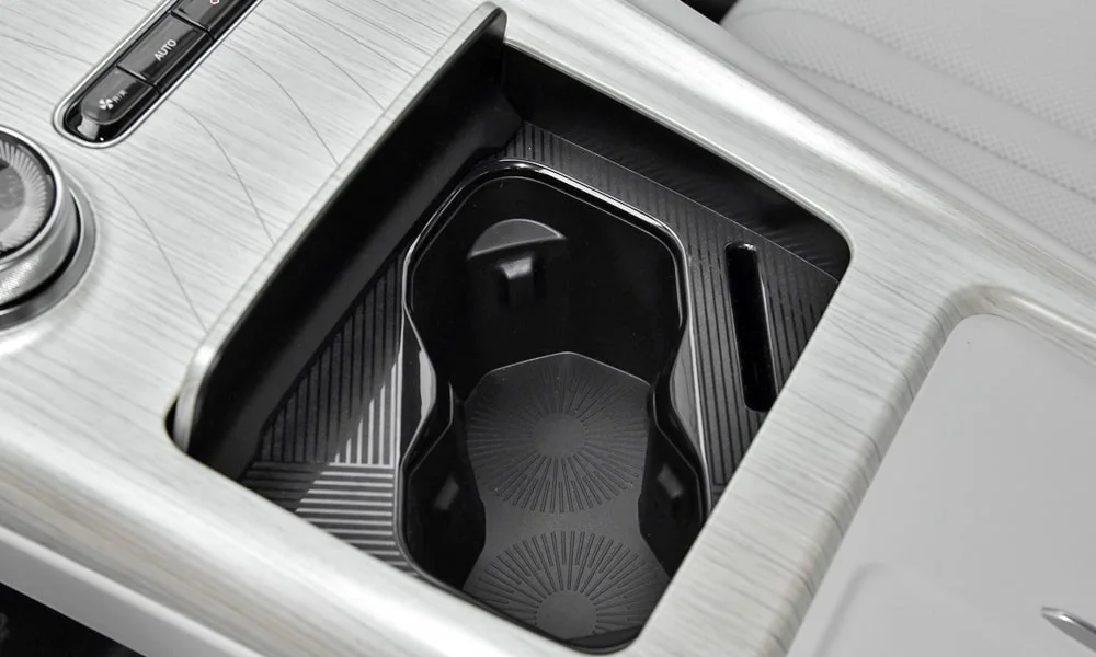 Фото Geely Galaxy EX5 (2024) — центральная консоль. Подстаканники и ниши для мелочей между креслами. Продуманное хранение: подстаканники, ниша для смартфона и глубокий бокс Geely Galaxy EX5 (2024) — центральная консоль