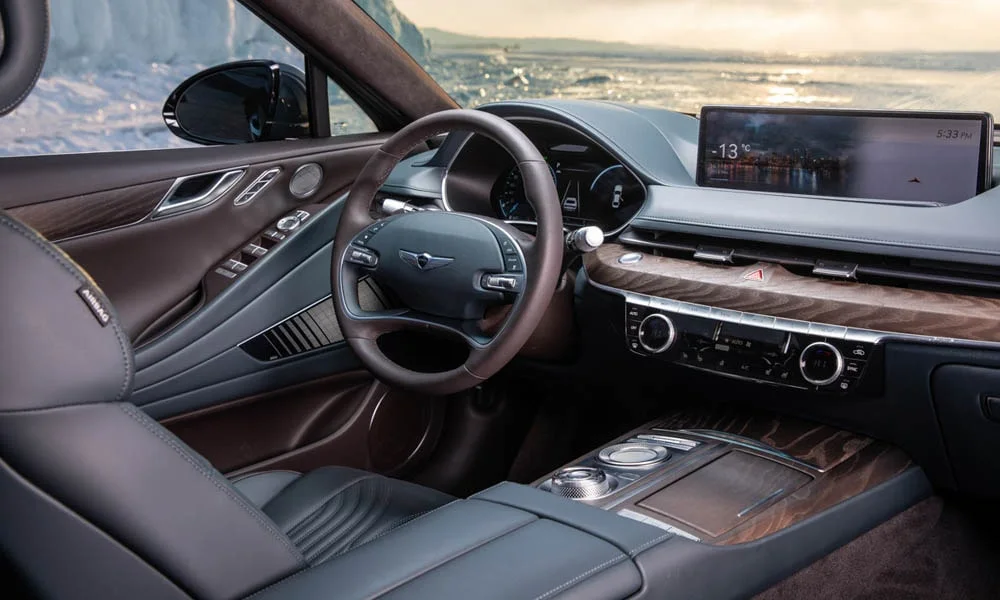 Фото Genesis G80 — передняя панель. Архитектура передней панели: ярусы, вставки и консоль в коричневой гамме. Минимум физических кнопок — ставка на экранное управление Genesis G80 — передняя панель