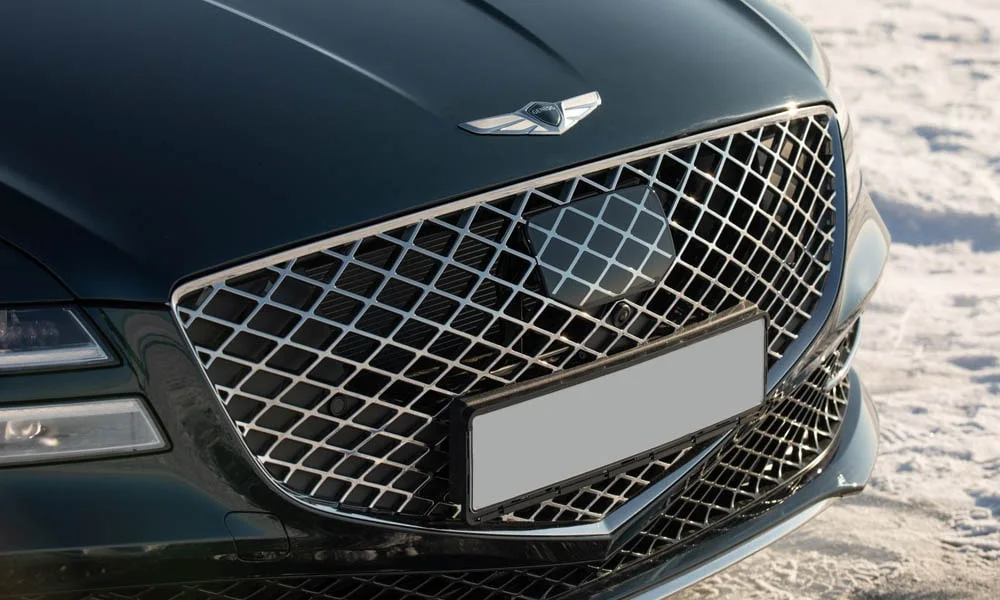 Фото Genesis G80 — решётка радиатора. Рисунок решётки: сетка, ламели или глухая панель у электроверсий. За решёткой у многих комплектаций стоит радар адаптивного круиз-контроля Genesis G80 — решётка радиатора
