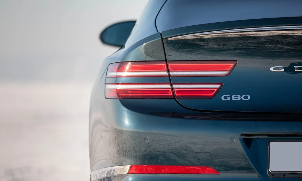 Фото Genesis G80 — задние фонари. Графика секций крупным планом — ночная подпись модели Genesis G80 — задние фонари