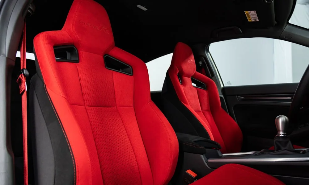 Фото Honda Civic Type R (2024) — передние сиденья. Профиль кресел: боковая поддержка и подголовники. Выраженная боковая поддержка держит в поворотах Honda Civic Type R (2024) — передние сиденья