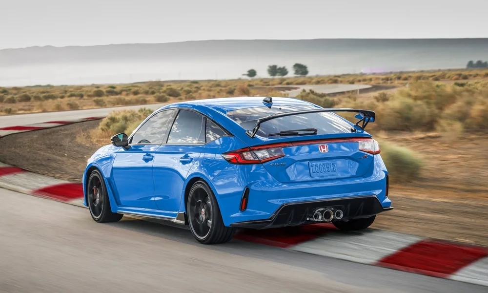 Фото Honda Civic Type R (2024) — вид сзади, фото 4. Синий кузов сзади — фонари и бампер определяют ночной образ модели. Насадки выхлопа или их имитация внизу бампера различают версии Honda Civic Type R (2024) — вид сзади, фото 4
