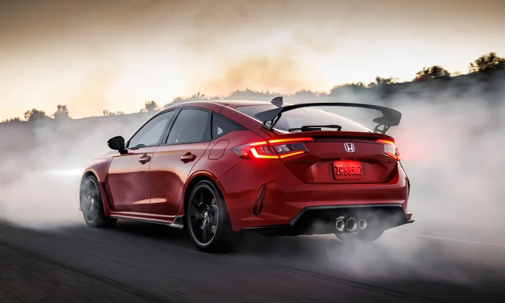 Фото Honda Civic Type R (2024) — вид сзади, фото 8. Линия крыши, стойки и задняя дверь в красном исполнении. Насадки выхлопа или их имитация внизу бампера различают версии Honda Civic Type R (2024) — вид сзади, фото 8