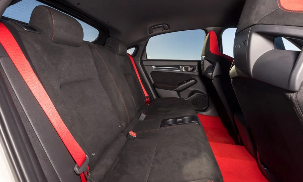 Фото Honda Civic Type R (2024) — задние сиденья. Посадка второго ряда: подголовники и подлокотник. Спинки складываются под длинные грузы у большинства версий Honda Civic Type R (2024) — задние сиденья
