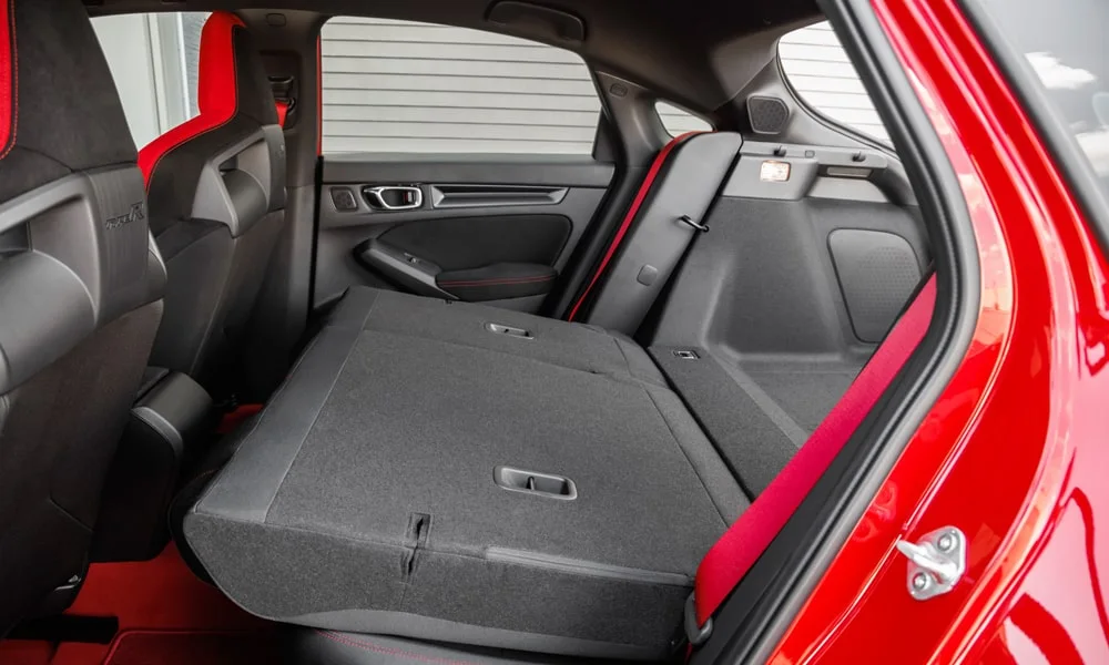 Фото Honda Civic Type R (2024) — багажник. Грузовой отсек с открытой дверью: погрузочная высота и ширина проёма. Спинки второго ряда складываются и расширяют отсек под длинные грузы Honda Civic Type R (2024) — багажник