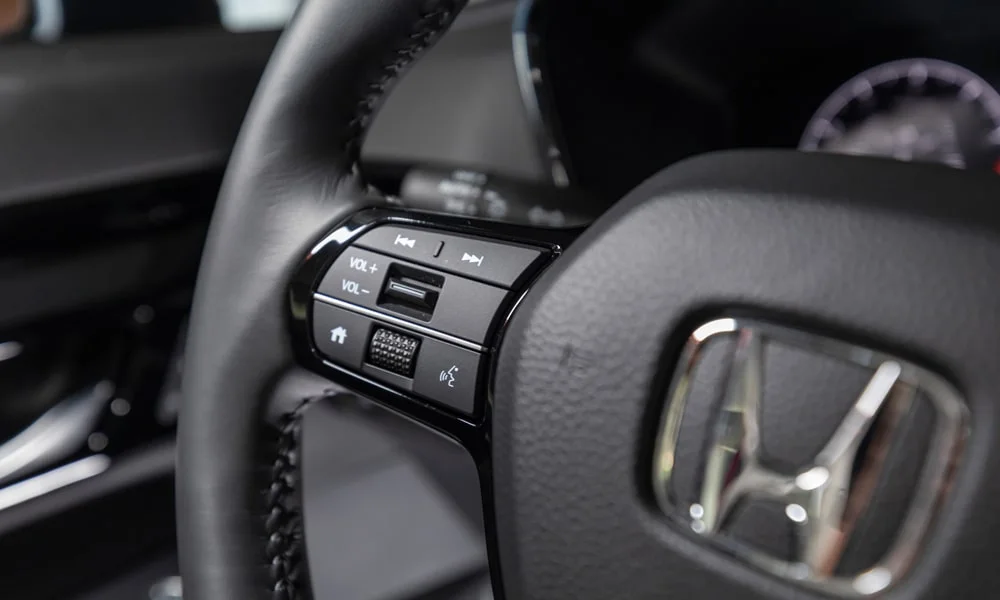 Фото Honda CR-V (2024) — руль, фото 2. Обшивка обода и компоновка спиц крупным планом. Клавиши на спицах управляют медиа, круизом и ассистентами — руки остаются на руле Honda CR-V (2024) — руль, фото 2