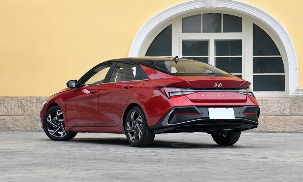 Фото Hyundai Elantra (2024) — вид сзади, фото 6. Линия крыши, стойки и задняя дверь в красном исполнении Hyundai Elantra (2024) — вид сзади, фото 6