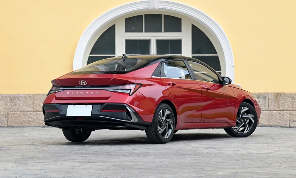 Фото Hyundai Elantra (2024) — вид сзади, фото 7. Линия крыши, стойки и задняя дверь в красном исполнении Hyundai Elantra (2024) — вид сзади, фото 7