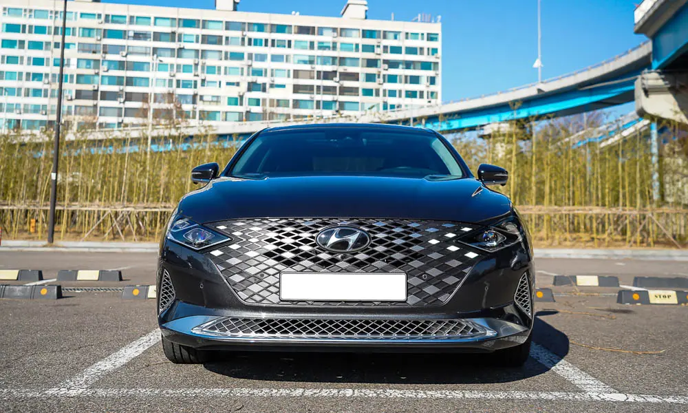 Фото Hyundai Grandeur — вид спереди. Оптика, решётка и бампер — первое впечатление о модели. Дневные ходовые огни включаются автоматически с запуском Hyundai Grandeur — вид спереди