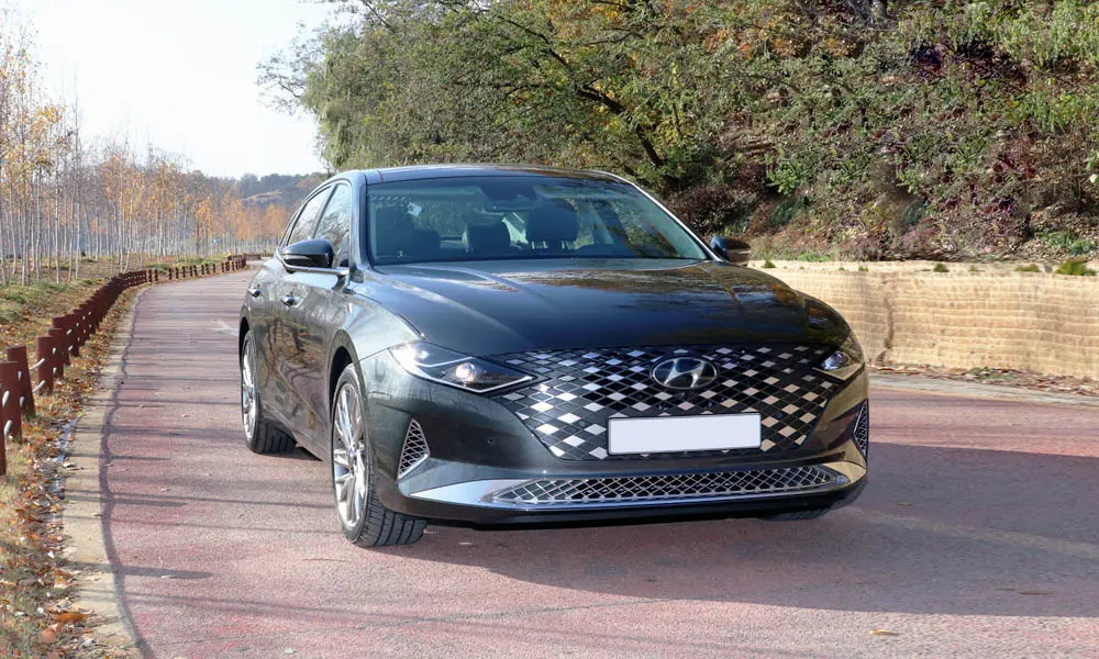 Фото Hyundai Grandeur — вид спереди, фото 4. Кузов в чёрном цвете: рисунок оптики и решётки задаёт узнаваемое «лицо» модели. Дневные ходовые огни включаются автоматически с запуском Hyundai Grandeur — вид спереди, фото 4