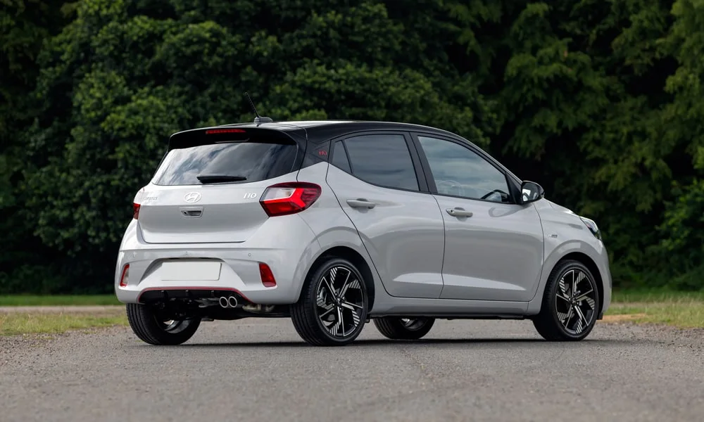 Фото Hyundai i10 — вид сзади, фото 7. Корма в белом цвете: графика фонарей и пластика пятой двери. Светодиодная полоса или раздельные секции — задняя оптика стала главным украшением кормы Hyundai i10 — вид сзади, фото 7