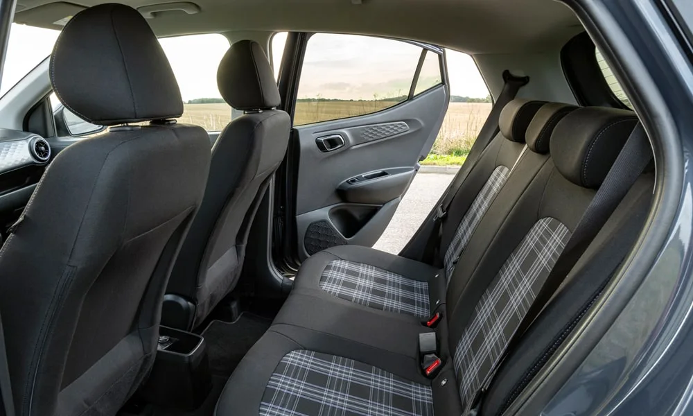 Фото Hyundai i10 — задние сиденья. Второй ряд: профиль дивана, подголовники и обивка из практичной ткани. Крепления ISOFIX для детских кресел — в основании спинки Hyundai i10 — задние сиденья