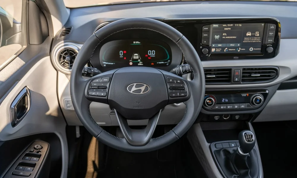 Фото Hyundai i10 — руль. Обшивка обода и компоновка спиц крупным планом. Обогрев обода — опция, которую оценят зимой Hyundai i10 — руль