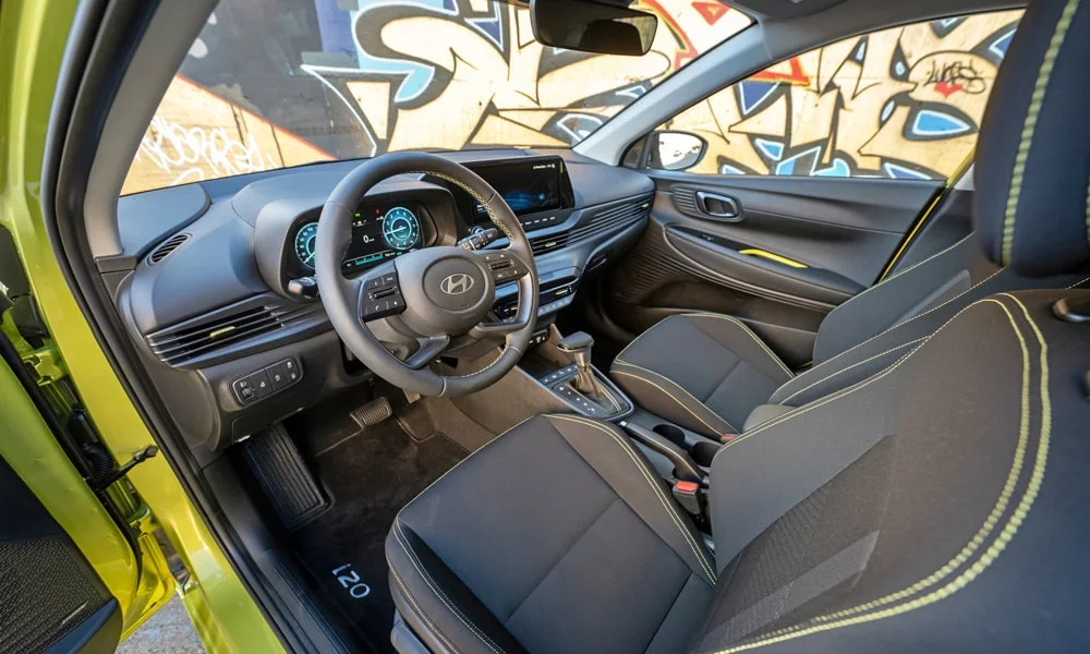 Фото Hyundai i20 — интерьер. Общий план салона: архитектура панели, консоль и кресла. Светлая гамма зрительно расширяет салон, тёмная — практичнее в уходе Hyundai i20 — интерьер