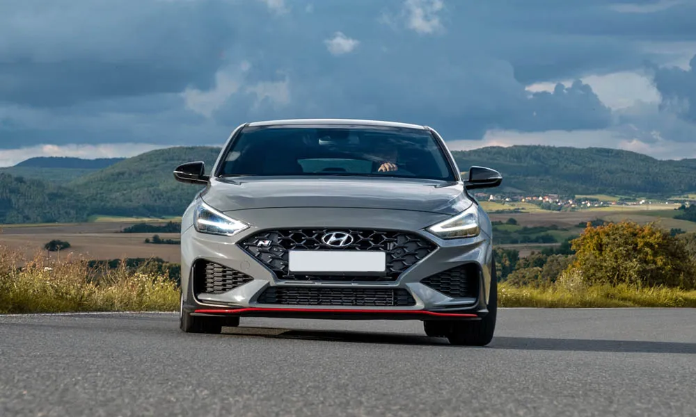 Фото Hyundai i30 Fastback N (2024) — вид спереди, фото 7. Анфас: пропорции капота, посадка кузова и графика ходовых огней Hyundai i30 Fastback N (2024) — вид спереди, фото 7
