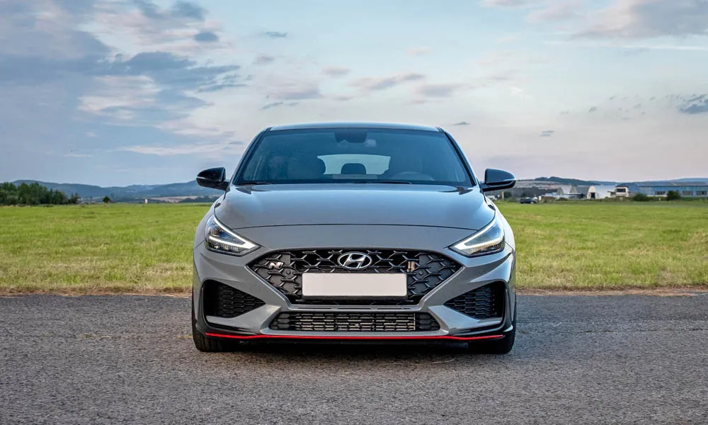Фото Hyundai i30 Fastback N (2024) — вид спереди, фото 11. Анфас: пропорции капота, посадка кузова и графика ходовых огней Hyundai i30 Fastback N (2024) — вид спереди, фото 11