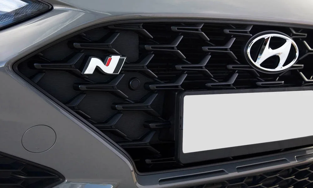 Фото Hyundai i30 Fastback N (2024) — решётка радиатора. Фирменный рисунок облицовки — визитная карточка марки Hyundai i30 Fastback N (2024) — решётка радиатора