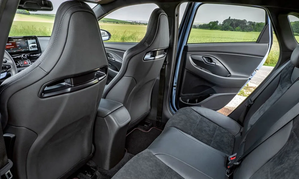 Фото Hyundai i30 Fastback N (2024) — интерьер. Общий план салона: архитектура панели, консоль и кресла. Уровень отделки читается по стыкам панелей и мягким поверхностям в зонах касания Hyundai i30 Fastback N (2024) — интерьер