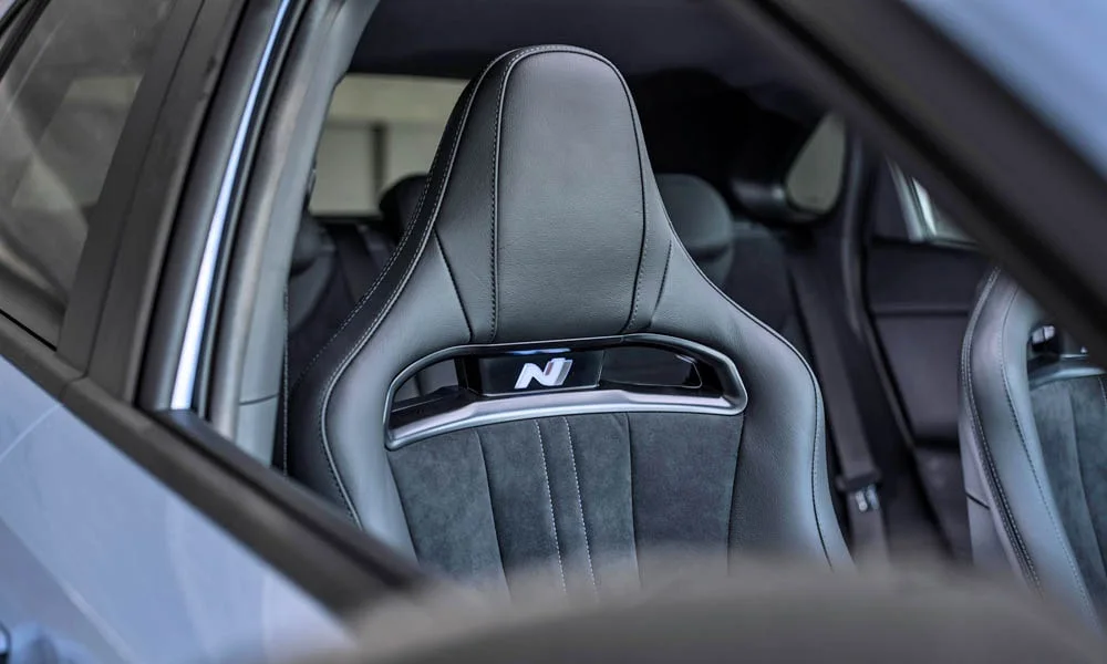 Фото Hyundai i30 Fastback N (2024) — интерьер, фото 2. Общий план салона: архитектура панели, консоль и кресла. Уровень отделки читается по стыкам панелей и мягким поверхностям в зонах касания Hyundai i30 Fastback N (2024) — интерьер, фото 2