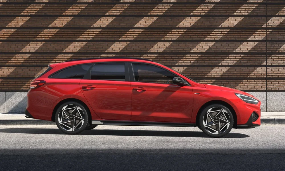 Фото Hyundai i30 — вид сбоку, фото 4. Красный кузов в профиль — пропорции, высота посадки и дизайн дисков. Хромированные или чёрные молдинги окон отличают комплектации Hyundai i30 — вид сбоку, фото 4