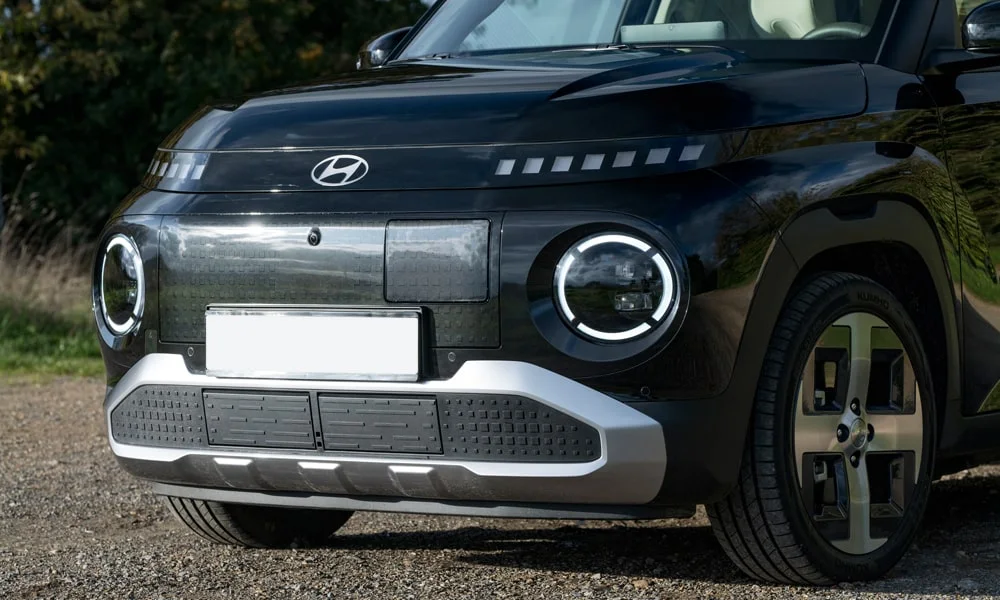 Фото Hyundai Inster — вид спереди, фото 5. Чёрный кузов, строгая симметрия оптики — базовый ракурс знакомства с дизайном Hyundai Inster — вид спереди, фото 5