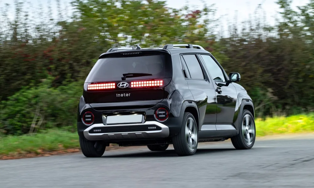 Фото Hyundai Inster — вид сзади, фото 4. Корма в чёрном цвете: графика фонарей и пластика пятой двери Hyundai Inster — вид сзади, фото 4