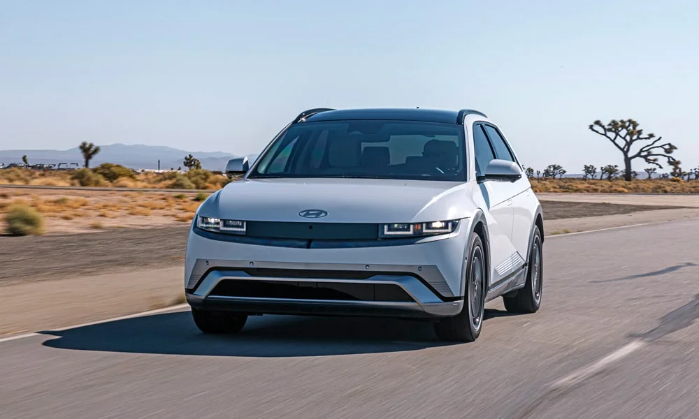 Фото Hyundai IONIQ 5 (2024) — вид спереди, фото 11. Передок в белом исполнении — крупная светотехника и выразительный бампер. Дневные ходовые огни включаются автоматически с запуском Hyundai IONIQ 5 (2024) — вид спереди, фото 11