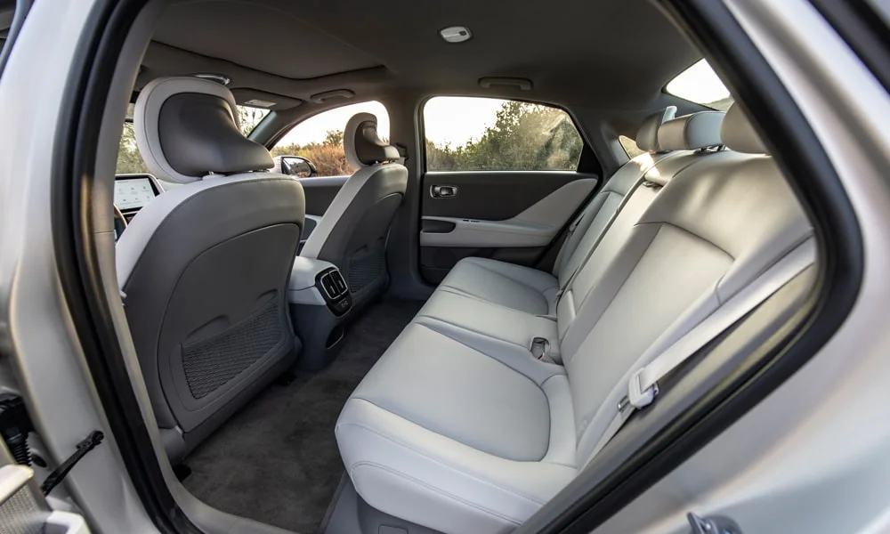 Фото Hyundai IONIQ 5 — задние сиденья, фото 2. Посадка второго ряда: подголовники и подлокотник. Спинки складываются под длинные грузы у большинства версий Hyundai IONIQ 5 — задние сиденья, фото 2