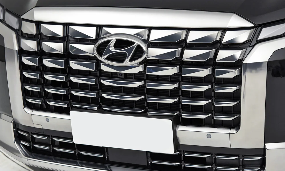 Фото Hyundai Palisade (2024) — решётка радиатора. Рисунок решётки: сетка, ламели или глухая панель у электроверсий. За решёткой у многих комплектаций стоит радар адаптивного круиз-контроля Hyundai Palisade (2024) — решётка радиатора