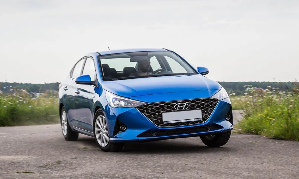 Фото Hyundai Solaris — вид спереди, фото 4. Кузов в синем цвете: рисунок оптики и решётки задаёт узнаваемое «лицо» модели. Дневные ходовые огни включаются автоматически с запуском Hyundai Solaris — вид спереди, фото 4