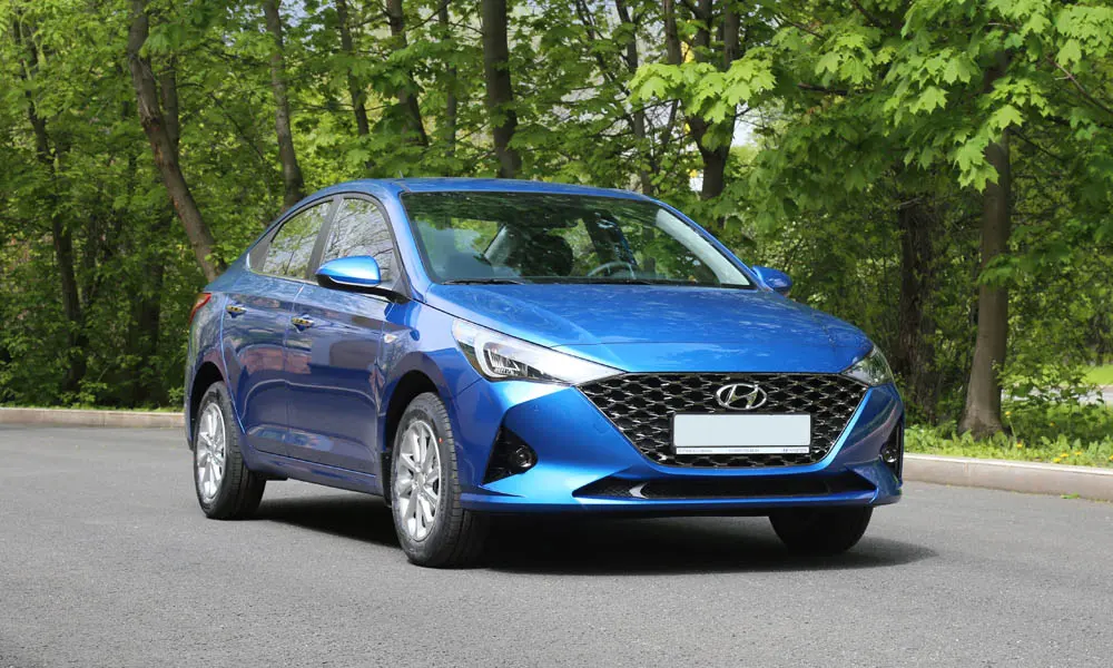 Фото Hyundai Solaris — вид спереди, фото 6. Кузов в синем цвете: рисунок оптики и решётки задаёт узнаваемое «лицо» модели. Дневные ходовые огни включаются автоматически с запуском Hyundai Solaris — вид спереди, фото 6