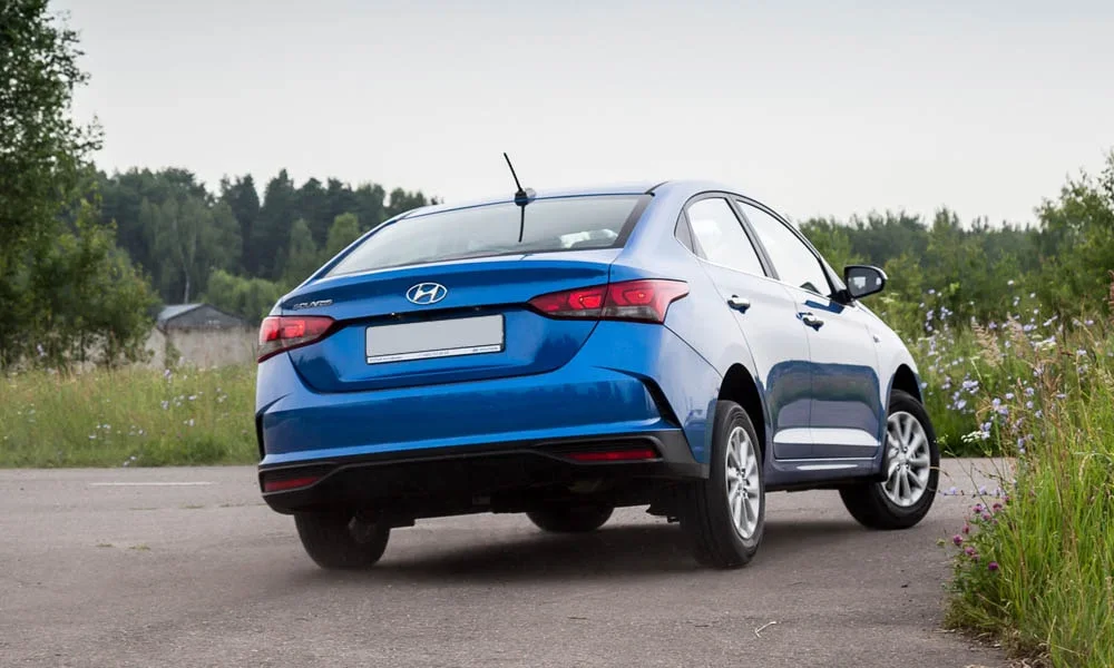 Фото Hyundai Solaris — вид сзади, фото 3. Корма в синем цвете: графика фонарей и пластика пятой двери. Насадки выхлопа или их имитация внизу бампера различают версии Hyundai Solaris — вид сзади, фото 3