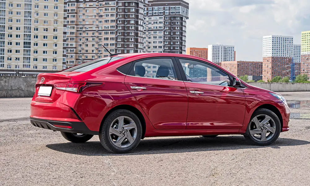 Фото Hyundai Solaris — вид сзади, фото 7. Линия крыши, стойки и задняя дверь в красном исполнении. Насадки выхлопа или их имитация внизу бампера различают версии Hyundai Solaris — вид сзади, фото 7
