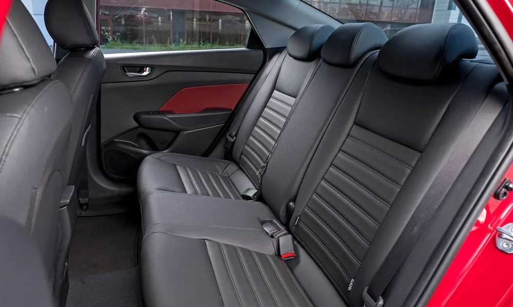 Фото Hyundai Solaris — задние сиденья, фото 2. Посадка второго ряда: подголовники и подлокотник. Спинки складываются под длинные грузы у большинства версий Hyundai Solaris — задние сиденья, фото 2
