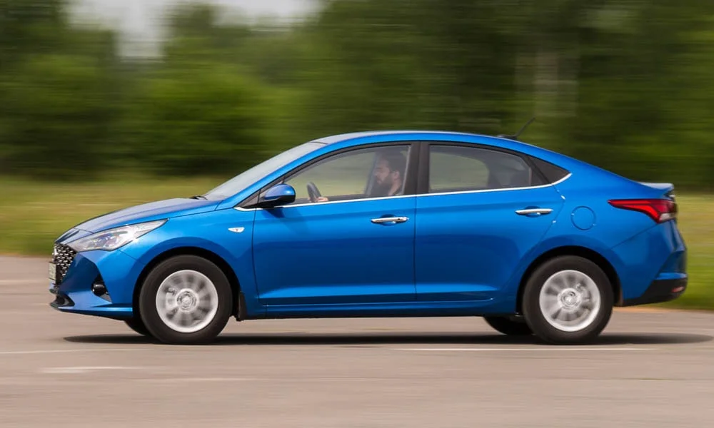 Фото Hyundai Solaris — вид сбоку, фото 2. Синий кузов в профиль — пропорции, высота посадки и дизайн дисков. Длинная база — простор второго ряда; короткие свесы упрощают парковку Hyundai Solaris — вид сбоку, фото 2