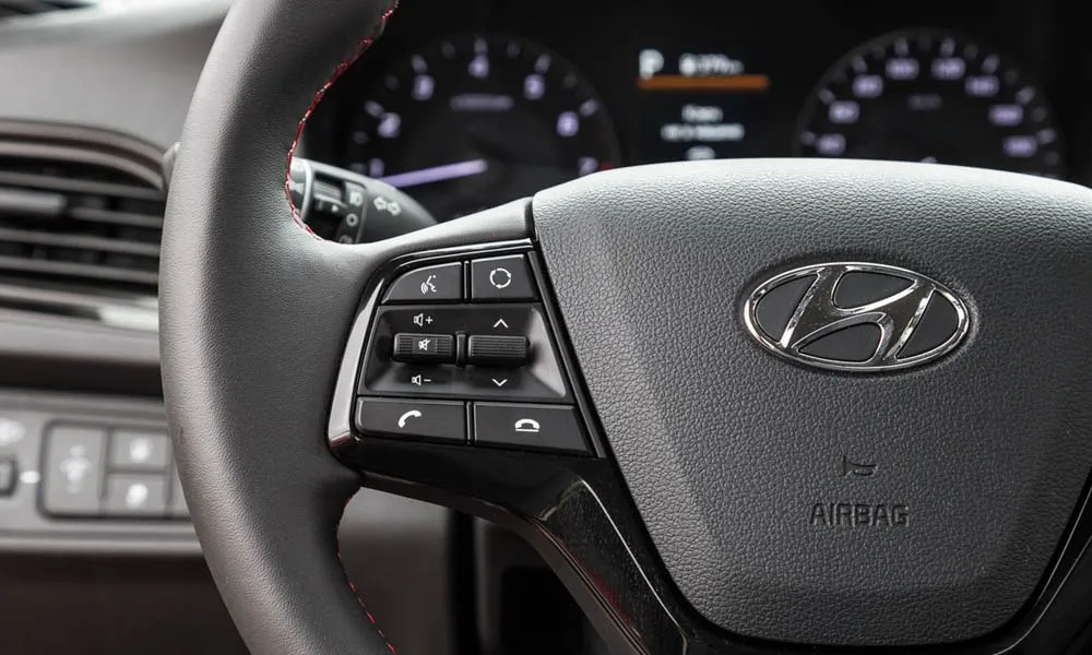 Фото Hyundai Solaris — руль, фото 4. Обшивка обода и компоновка спиц крупным планом. Клавиши на спицах управляют медиа, круизом и ассистентами — руки остаются на руле Hyundai Solaris — руль, фото 4