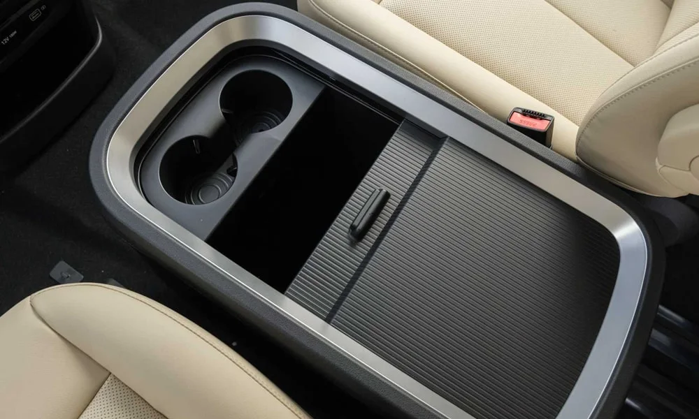 Фото Hyundai Staria (2022) — центральная консоль. Бокс консоли открыт: организация хранения между креслами. Прорезиненное дно ниш удерживает мелочи в поворотах Hyundai Staria (2022) — центральная консоль