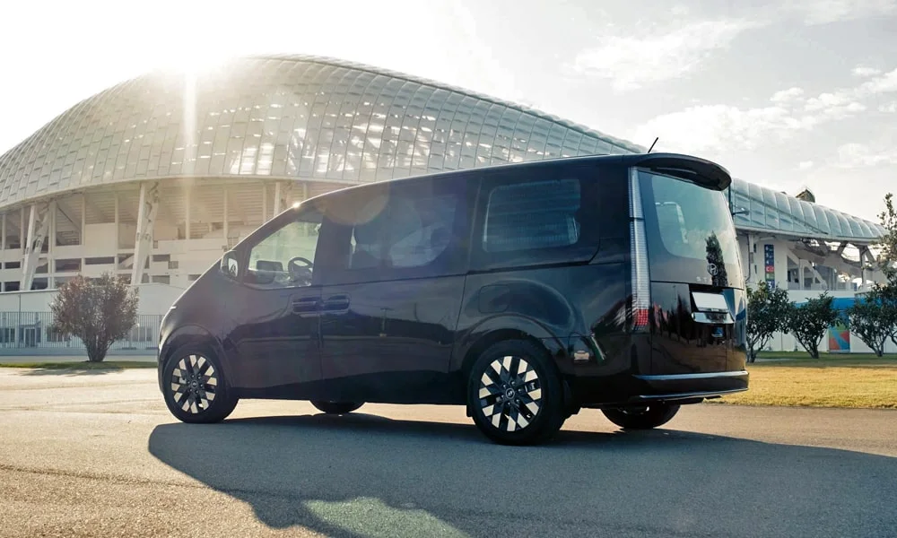 Фото Hyundai Staria (2022) — вид сзади, фото 3. Корма в чёрном цвете: графика фонарей и пластика пятой двери. Насадки выхлопа или их имитация внизу бампера различают версии Hyundai Staria (2022) — вид сзади, фото 3