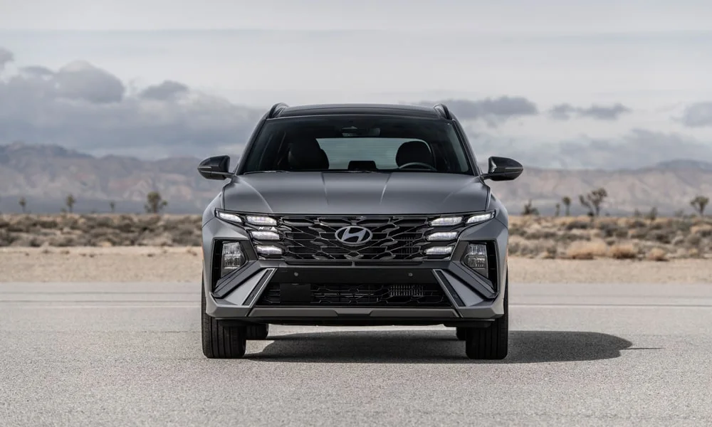 Фото Hyundai Tucson N Line (2024) — вид спереди, фото 2. Серый кузов, строгая симметрия оптики — базовый ракурс знакомства с дизайном. Дневные ходовые огни включаются автоматически с запуском Hyundai Tucson N Line (2024) — вид спереди, фото 2