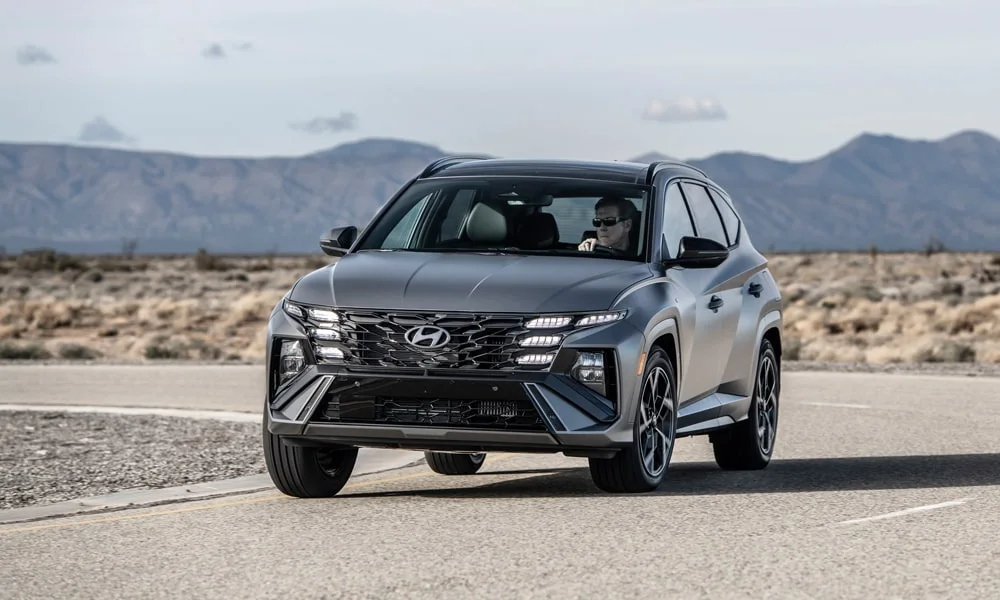 Фото Hyundai Tucson N Line (2024) — вид спереди, фото 8. Кузов в сером цвете: рисунок оптики и решётки задаёт узнаваемое «лицо» модели. Дневные ходовые огни включаются автоматически с запуском Hyundai Tucson N Line (2024) — вид спереди, фото 8